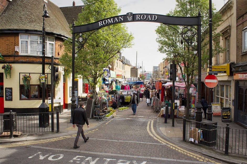 People walking down Roman Road Market in Bow.