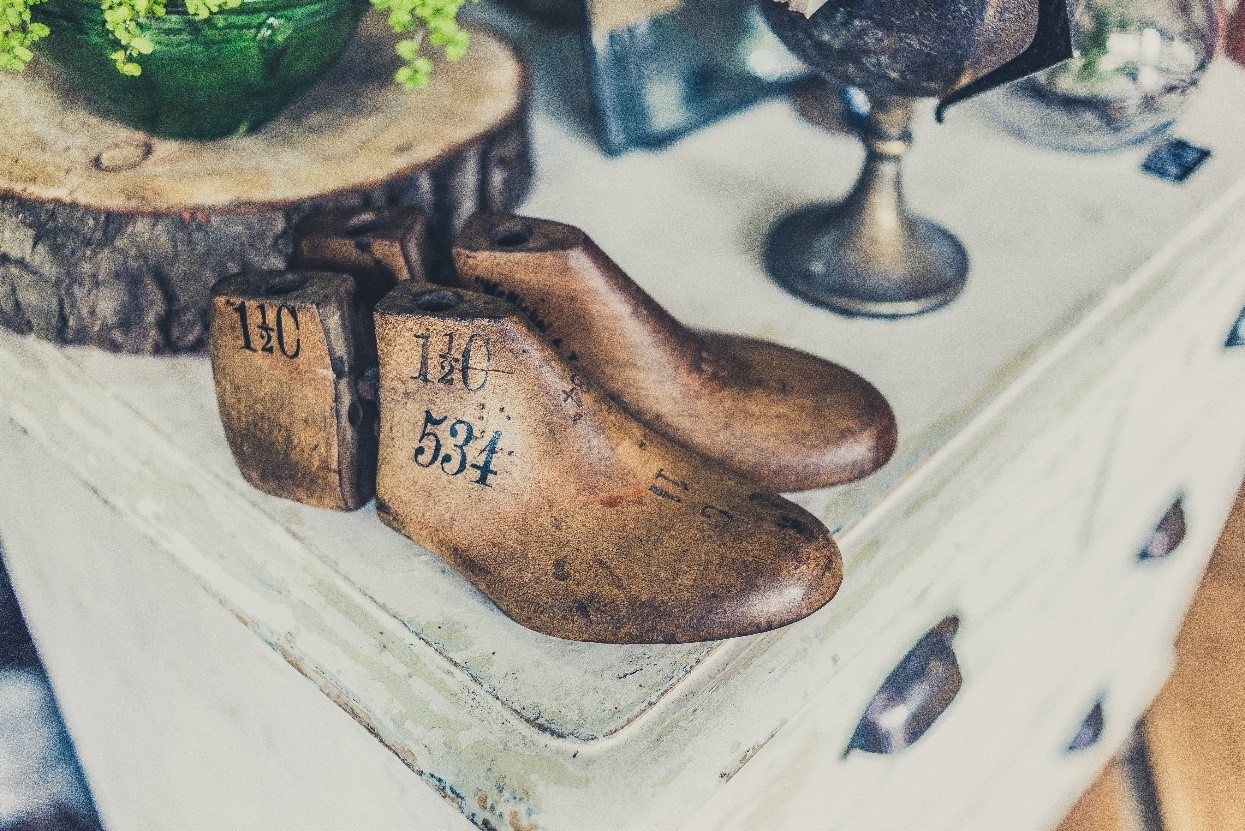 Wooden boot mannequins on display on a chest of drawers in Camden.