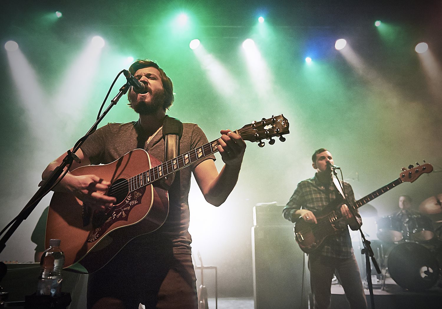 Live music in Shepherds bush – singer playing a guitar with band and backup guitarists in the background.