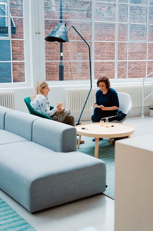 Two women discussing ideas in an open office space.