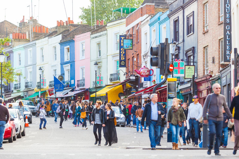 People walking down Portobello Market, street lined with shops.